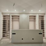 Vestidor a medida con puertas lacadas crema y uñero integrado, interior en melamina tono sal y luz LED en Martorell